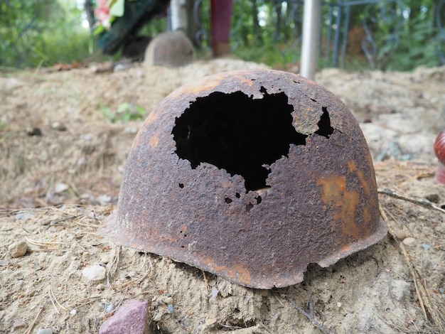 Autentico casco della seconda guerra mondiale con casco arrugginito con foro di proiettile sulla tomba commemorativa di orzega kare