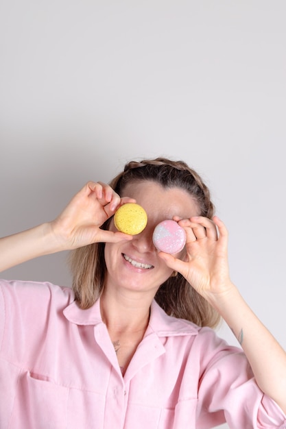 Autentico ritratto di donna con macarons nella foto di stile di vita del pasticcere delle mani