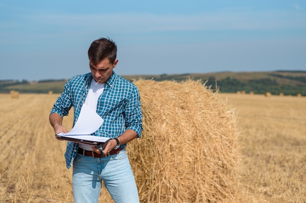 Autentico ritratto frontale dell'agronomo giovane agricoltore nel pagliaio