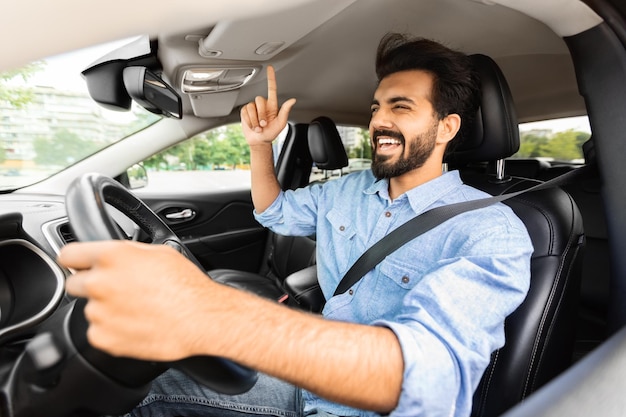 Autista arabo emotivo che si diverte durante il viaggio in macchina