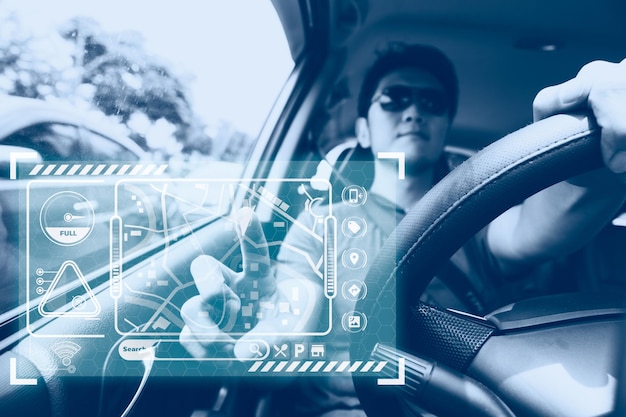 Autista di auto maschio che utilizza il sistema di navigazione GPS sulla tecnologia moderna del pannello a sfioramento dell'ologramma per l'assistente di trasporto