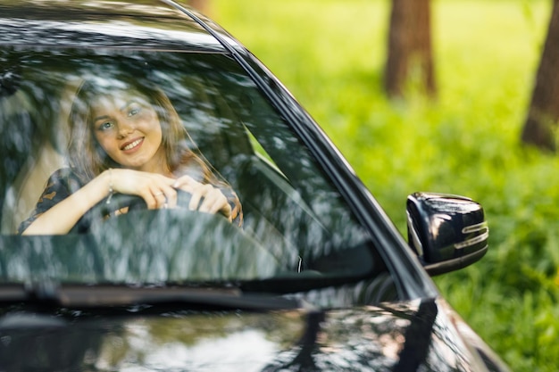 Autista di donna felice in macchina sorridente Carino giovane donna bruna felice guida auto veicolo copia spazio