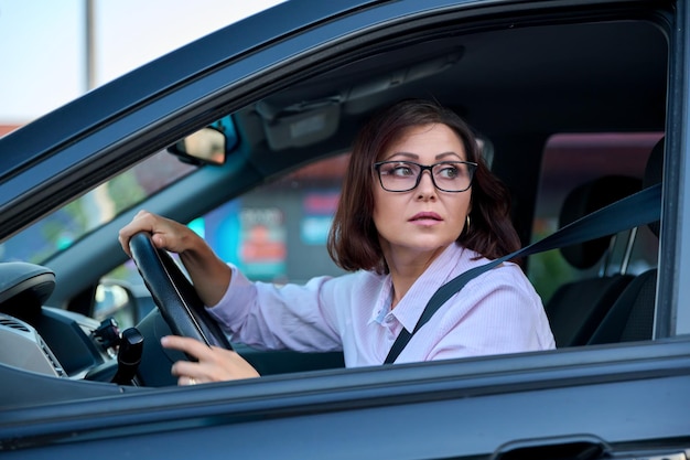 Autista di mezza età bella donna che guida un'auto