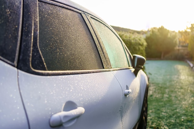 Auto bianca ricoperta di ghiaccio all'alba a causa del freddo intenso dell'inverno