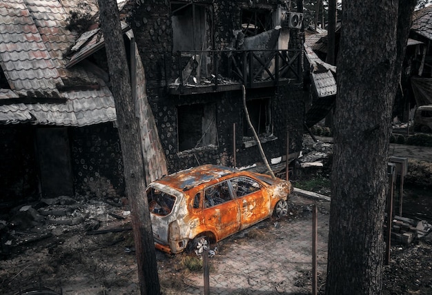 Auto bruciata e edificio distrutto Conseguenze dei colpi di mortaio Guerra in Ucraina