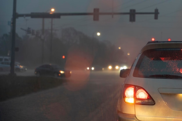 Auto che guidano per la strada della città della Florida di notte durante una forte pioggia con traffico in movimento durante l'ora di punta Sistema di trasporto negli Stati Uniti