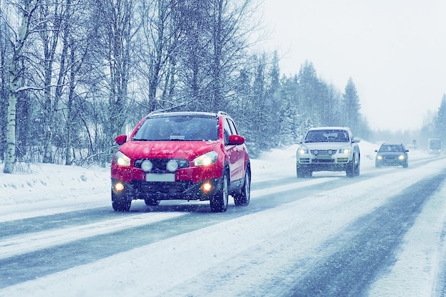 Auto con lampada frontale sulla strada innevata in inverno Rovaniemi, in Lapponia, Finlandia. Alla nevicata