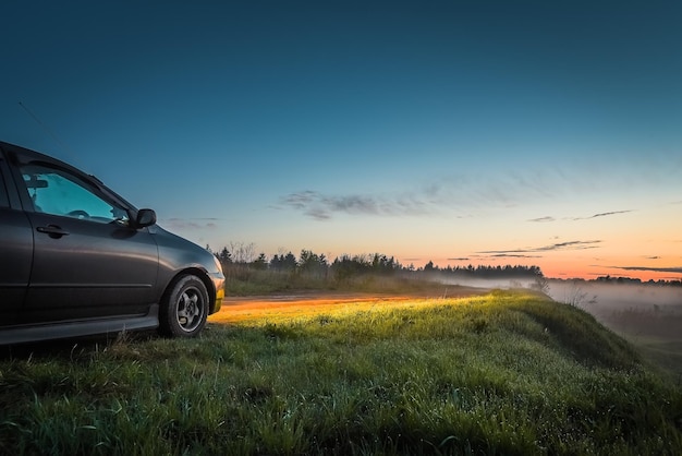 Auto e luce dei fari al tramonto all'aperto