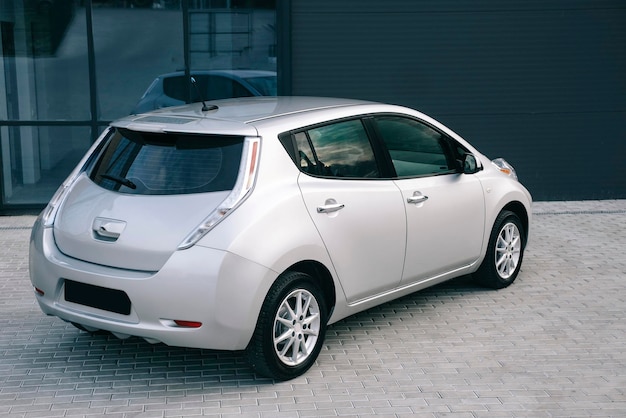 Auto elettrica moderna. Ricarica di veicoli elettrici presso una stazione nel parcheggio.