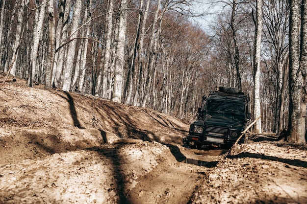 Auto fuoristrada che guida attraverso la strada forestale di fango