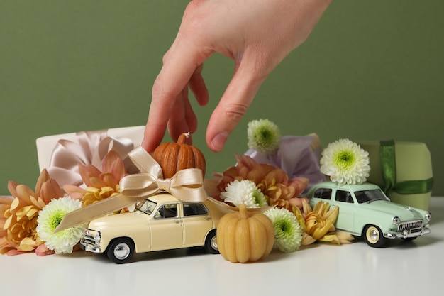 Auto giocattolo retro con regali fiori e una zucca