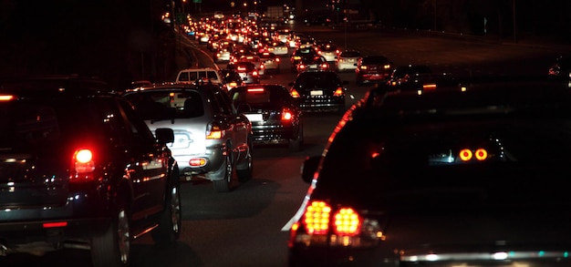 Auto illuminate che si muovono per strada in città di notte