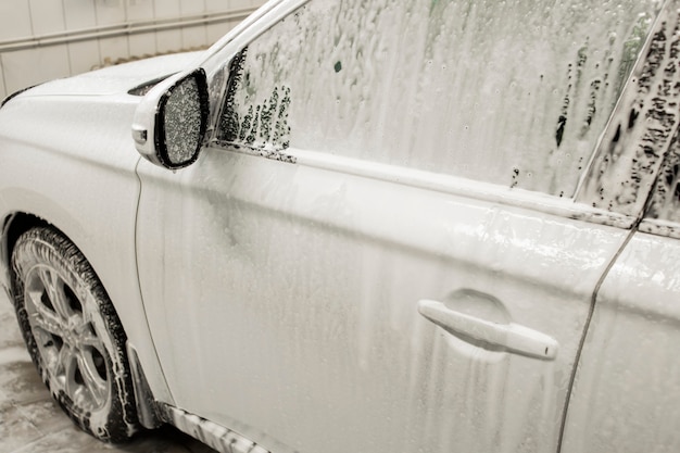 Auto in auto schiuma che si lava con il lavaggio dell'auto con sapone