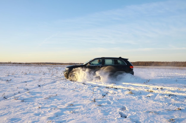 Auto in campo in inverno. Cumuli di neve invernali fuoristrada. Sport estremo, divertimento.