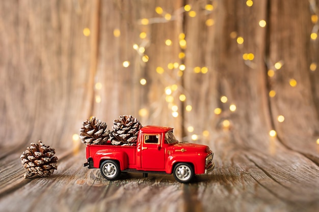 Auto in miniatura su fondo in legno con luci natalizie