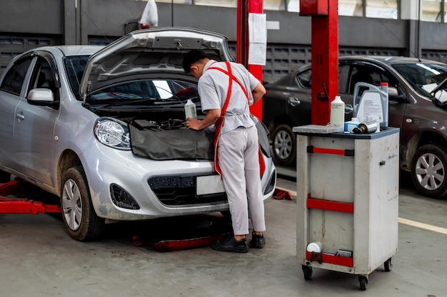 Auto in stazione di riparazione e carrozzeria con soft focus e luce sullo sfondo