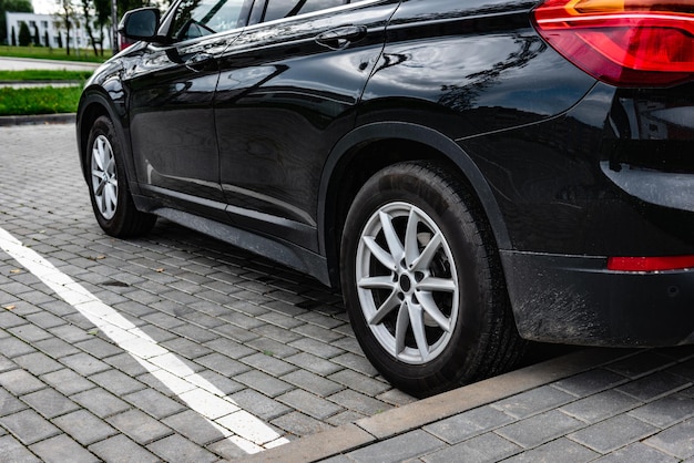 Auto nera parcheggiata nel parcheggio esterno.