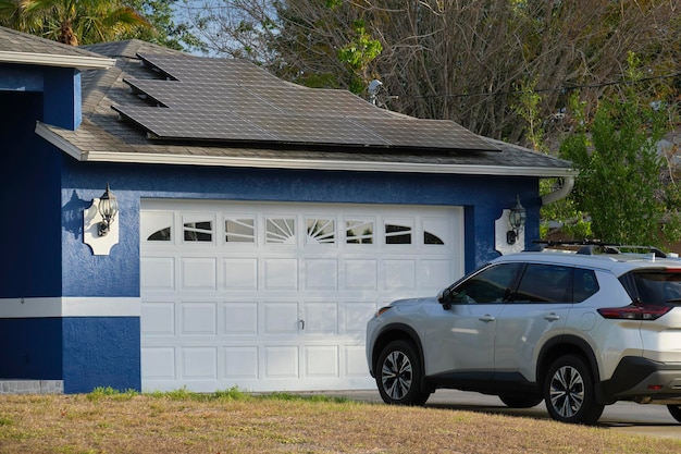 Auto parcheggiata di fronte all'ampia porta doppia del garage sul vialetto in cemento della nuova casa americana moderna