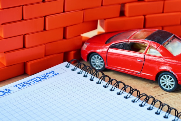 Auto rossa in miniatura si è schiantato in un muro di mattoni e modulo di assicurazione auto