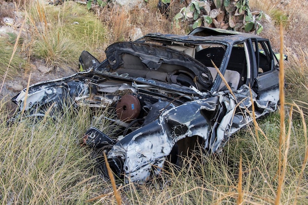 Auto rotta e auto abbandonata incidente d'auto dopo l'incidente incidente stradale auto in frantumi auto abbandonata auto danneggiata auto arrugginita in un campo di prateria