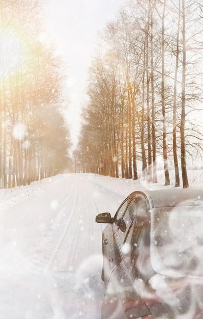 Auto su una strada invernale innevata nei campi.