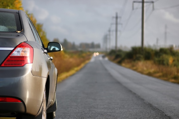 Auto sulla corsia della strada di campagna in una piovosa giornata autunnale