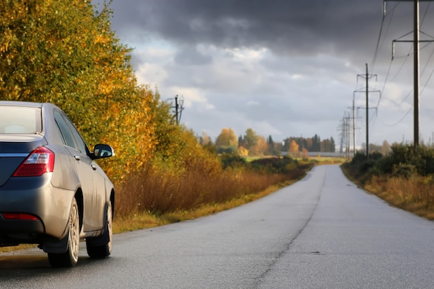 Auto sulla corsia della strada di campagna in una piovosa giornata autunnale