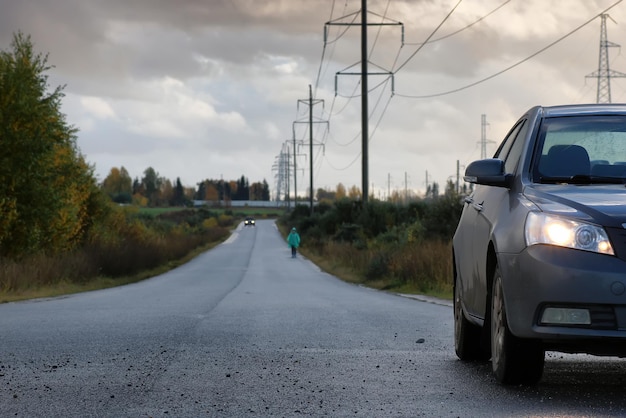 Auto sulla corsia della strada di campagna in una piovosa giornata autunnale