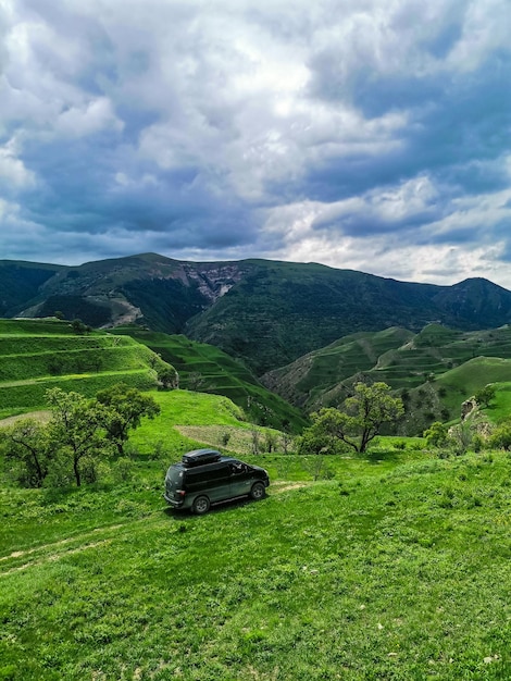 Auto sullo sfondo con vista sulle montagne del Daghestan vicino al villaggio di Gamsutl Russia giugno 2021