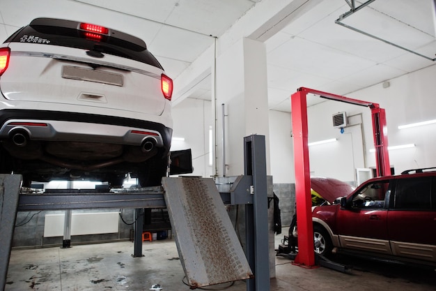 Auto SUV americana su supporto per il controllo del camber di allineamento delle ruote nell'officina della stazione di servizio