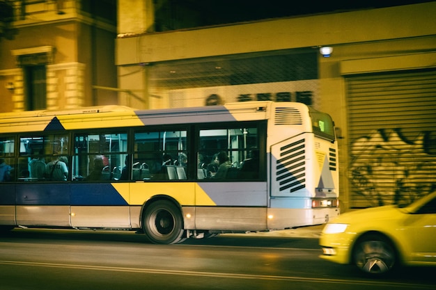 Autobus e taxi in movimento ad Atene, in Grecia, di notte