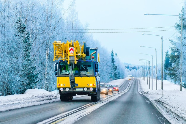 Autocarro con gru di sollevamento su strada in inverno Rovaniemi, Lapponia, Finlandia