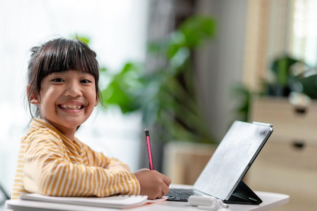 Autoisolamento del bambino utilizzando il tablet per i compitiBambino che utilizza il tablet digitale alla ricerca di informazioni su Internet durante il blocco del covid 19Istruzione domiciliareDistanza socialeElearning Istruzione online