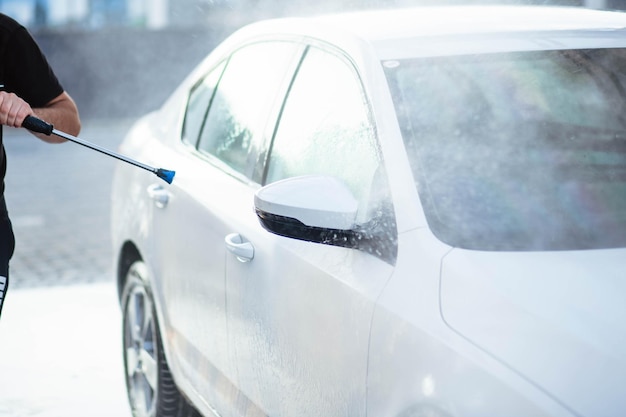 Autolavaggio estivo Pulizia dell'auto con acqua ad alta pressione Autolavaggio con sapone Concetto di primo piano Misure di sicurezza durante l'epidemia Disinfezione concettuale e pulizia antisettica Autolavaggio