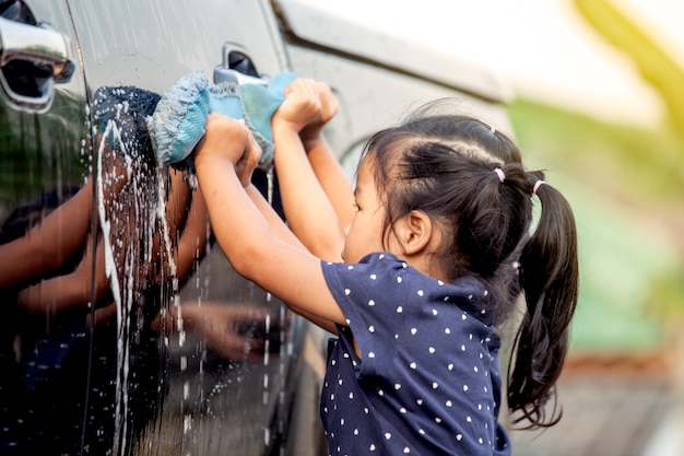 Automobile asiatica sveglia di lavaggio della bambina nel tono di colore dell&#39;annata