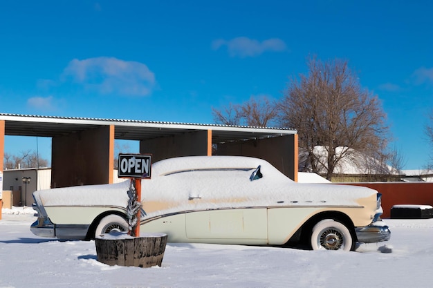 Automobile bianca antiquata abbandonata e coperta di neve