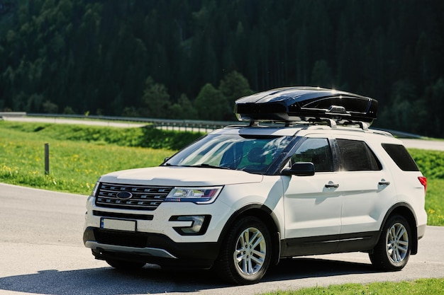 Automobile bianca di SUV con il cassone di carico del portapacchi su strada in Untertauern Austria