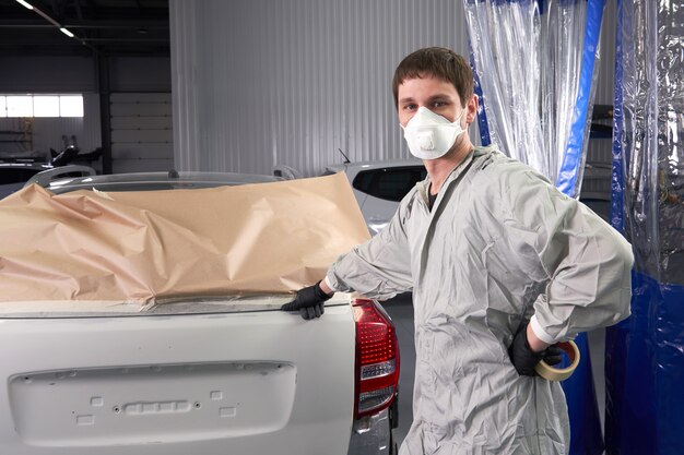 Automobile della copertura del meccanico prima della verniciatura nel servizio di riparazione automatica