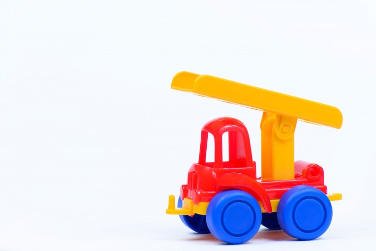 Automobile di plastica del giocattolo su una parete bianca