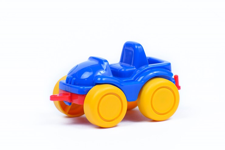 Automobile di plastica del giocattolo su una parete bianca
