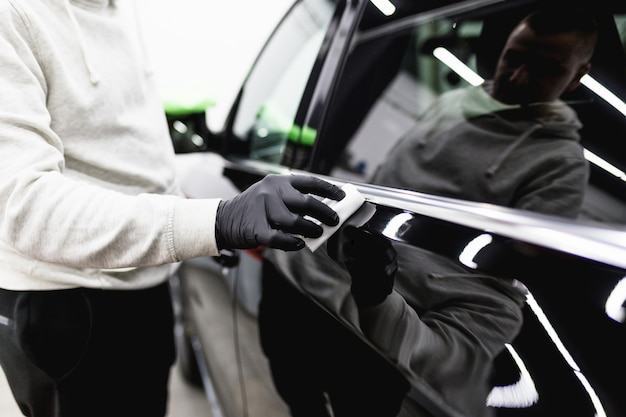 Automobile di pulizia dell'operaio - concetto che dettaglia (o valeting) dell'automobile. Messa a fuoco selettiva.