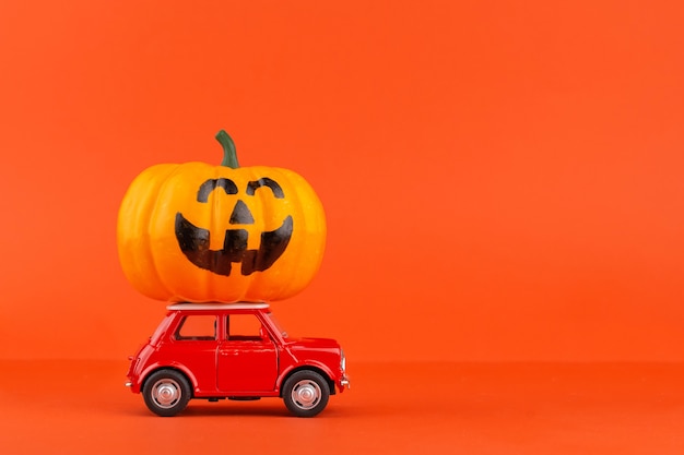 Automobile rossa del giocattolo con una zucca isolata