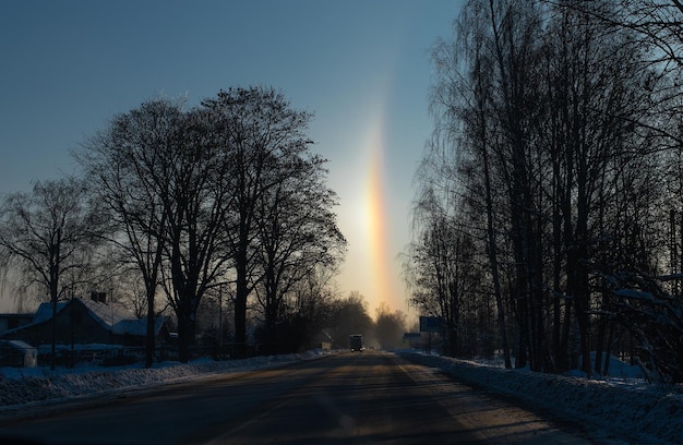 Automobili su strada invernale e arcobaleno