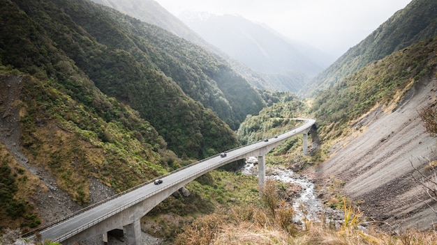 Autostrada che si snoda attraverso la verde valle di montagna colpo di otira viadotto Arthurs pass national park