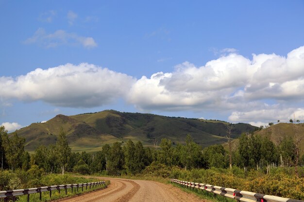 Autostrada in campagna tra colline e alberiViaggi vacanze estive autoturismo