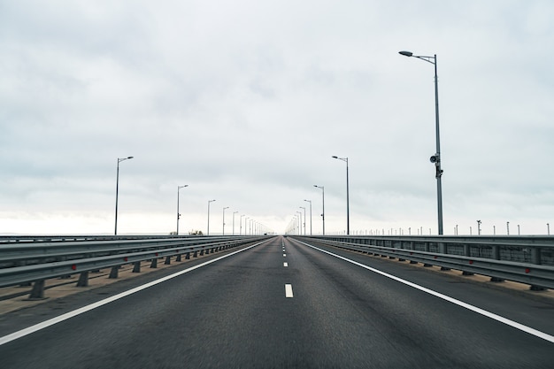 Autostrada vuota con strada asfaltata e cielo nuvoloso