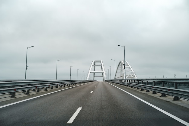 Autostrada vuota con strada asfaltata e cielo nuvoloso