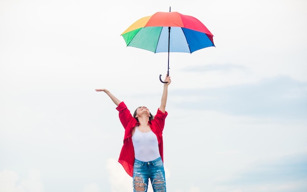 Autunno accogliente Bella donna con ombrello colorato Ombrello arcobaleno Tempo piovoso Buon umore Buone vibrazioni Persona di mentalità aperta Ragazza che si sente bene sullo sfondo del cielo Facile e gratuito Bel tempo