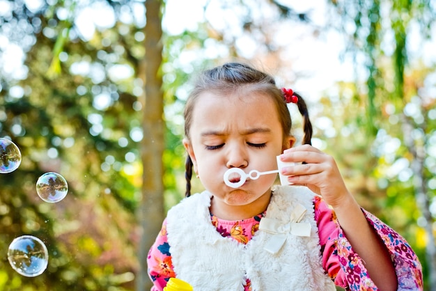 Autunno Allegra bambina che soffia bolle di sapone