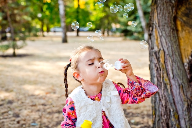 Autunno Allegra bambina che soffia bolle di sapone